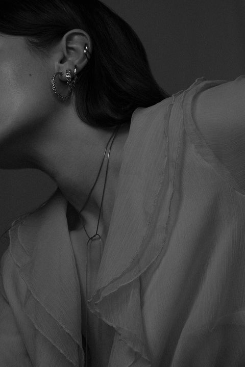 A handcrafted choker combining two 33 mm silver tube elements with a 120 cm chain. Designed for versatile styling, the chain can be tied, layered, or worn loose, including as a back neckline accent. Elegant silver ends ensure a perfect drape and refined finish. Discover modern, adaptable jewelry by UMIAR jewelry.