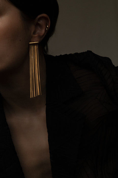 Decorative stud earrings featuring delicate dangling chains that sway gracefully with movement. An elegant, eye-catching design that adds fluidity and sophistication to any outfit, from daywear to evening styling. Discover refined elegance and modern detail by UMIAR jewelry.