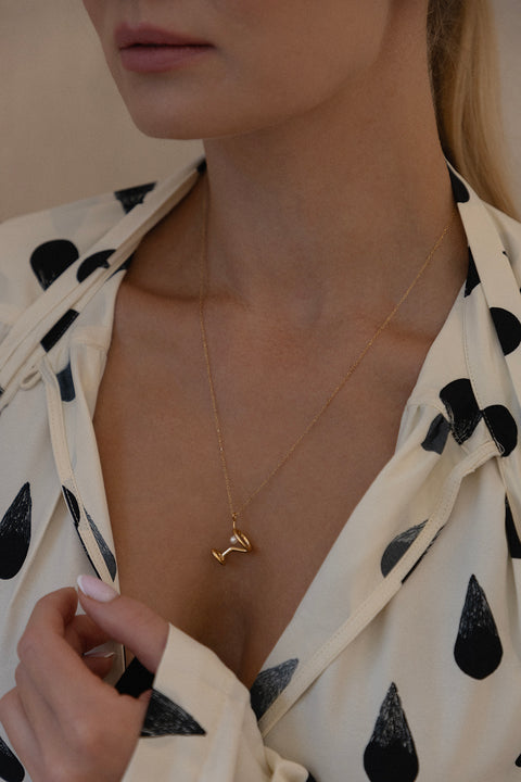A unique necklace inspired by the shape of a martini glass, created to mark the opening of the Jewellery Bar boutique. Featuring a natural pearl symbolizing the cocktail’s olive and a 50 cm chain, this design blends playful elegance with refined craftsmanship. Discover distinctive storytelling jewelry by UMIAR jewelry.