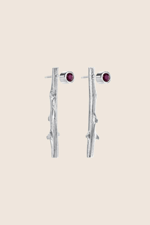 Discover two-part earrings set with rubies and inspired by the branch of a rose by UMIAR jewellery. Their design blends simple forms with refined texture, highlighting the natural beauty of the stones. Crafted from 925 sterling silver and 925 silver plated with 24-carat gold, they are an elegant addition to any look. Let the charm of the rose grace your ears today!