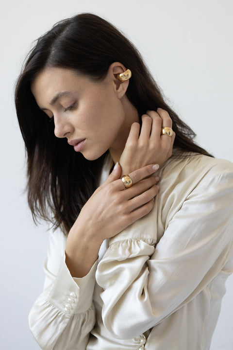 Discover the bold, oversized ear cuff with a rounded cylindrical shape from the RONDA collection by UMIAR jewelry. Handcrafted from 925 sterling silver and 24k gold, this avant-garde ear cuff perfectly contrasts its smooth, mirror-like surface with a streamlined form. Perfect for minimalist outfits. Buy now and add elegance to your everyday and evening looks!