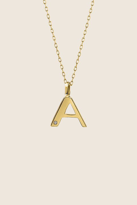A delicate letter A pendant necklace inlaid with a natural diamond of 0.007 ct and 1.2 mm diameter. Suspended on a 50 cm chain, this timeless initial design offers a personal and elegant way to celebrate someone special. A refined keepsake that never goes out of style. Discover meaningful jewelry by UMIAR jewelry.