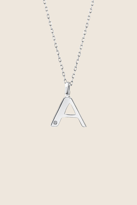 A delicate letter A pendant necklace inlaid with a natural diamond of 0.007 ct and 1.2 mm diameter. Suspended on a 50 cm chain, this timeless initial design offers a personal and elegant way to celebrate someone special. A refined keepsake that never goes out of style. Discover meaningful jewelry by UMIAR jewelry.