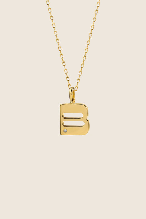 A delicate letter B pendant necklace inlaid with a natural diamond of 0.007 ct and 1.2 mm diameter. Suspended on a 50 cm chain, this timeless initial design offers a personal and elegant way to celebrate someone special. A refined keepsake that never goes out of style. Discover meaningful jewelry by UMIAR jewelry.