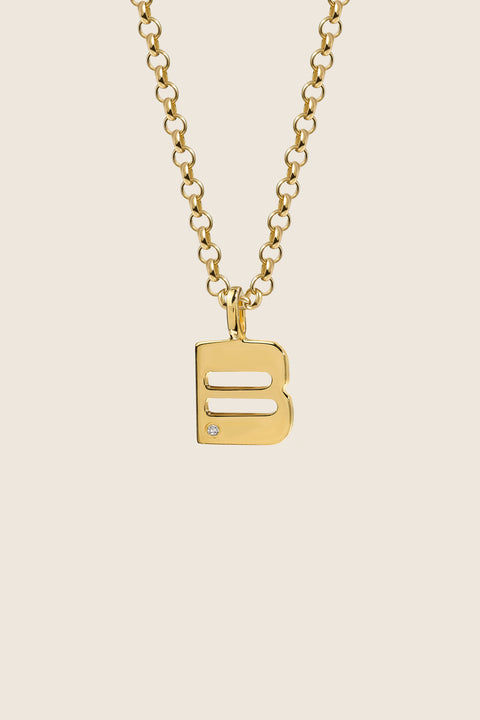 A delicate letter B pendant necklace inlaid with a natural diamond of 0.007 ct and 1.2 mm diameter. Suspended on a 50 cm chain, this timeless initial design offers a personal and elegant way to celebrate someone special. A refined keepsake that never goes out of style. Discover meaningful jewelry by UMIAR jewelry.