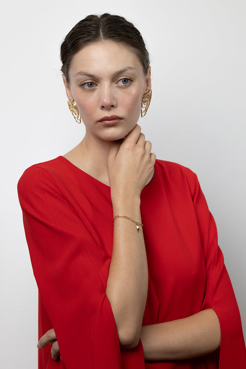 This minimalist chain bracelet from UMIAR’s PROFONDO ROSSO collection features an elegant pendant inspired by the thorn of a rose. Subtly set with a natural ruby (2 mm, 0.05 ct), it carries a distinctive and refined character. Handcrafted from precious materials — 925 sterling silver and 925 silver plated with 24-carat gold.