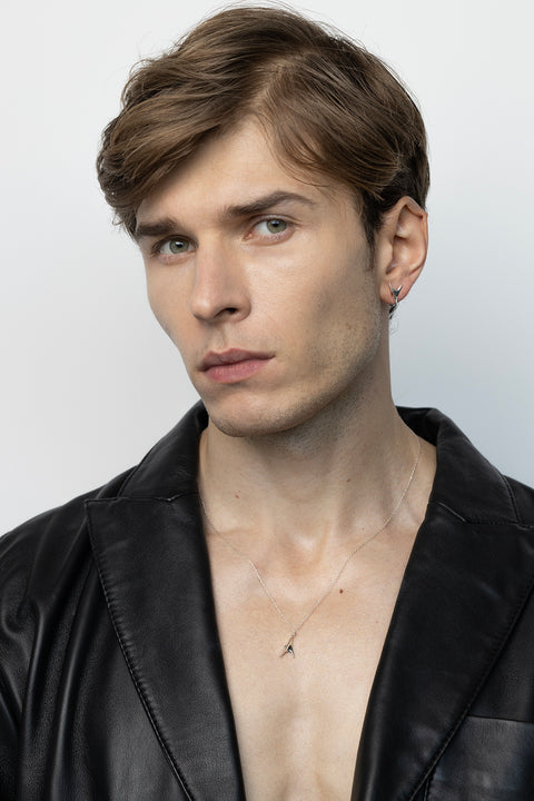 Discover our minimalist necklace featuring a pendant inspired by the delicate thorn of a rose — a subtle way to elevate your elegant style. The design is accented with a natural ruby (2 mm, 0.05 ct) for a refined touch of colour. Handcrafted entirely from precious materials: 925 sterling silver or 925 silver plated with 24-carat gold.