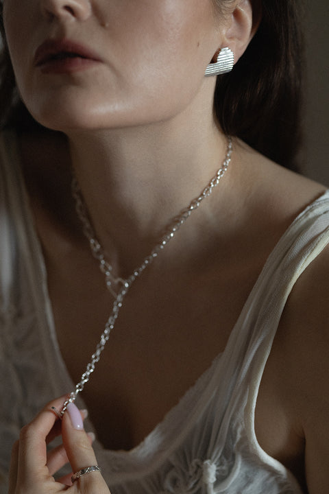 Large, statement heart-shaped earrings with dynamic fluted lines. Avant-garde yet elegant — perfect for power-dressing looks and minimalist outfits alike. Handcrafted from 925 sterling silver and beautifully reflective. An ideal Valentine’s gift. Discover UMIAR jewellery!