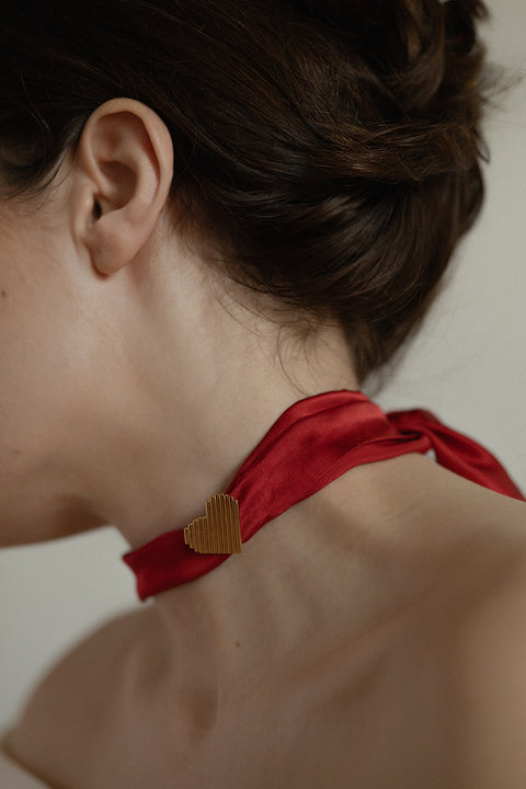 A bold heart necklace adorned with dynamic fluted lines — avant-garde yet timeless. Suspended from a silk ribbon and inspired by ’90s aesthetics, it makes an unforgettable Valentine’s gift. Discover UMIAR’s unique jewellery and give something truly special!