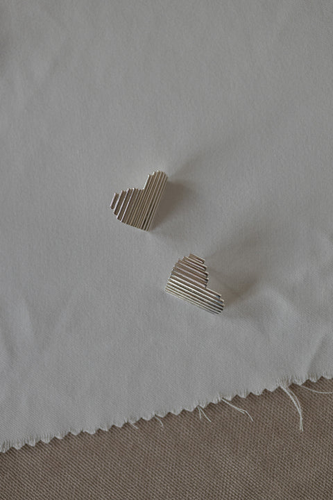Large, statement heart-shaped earrings with dynamic fluted lines. Avant-garde yet elegant — perfect for power-dressing looks and minimalist outfits alike. Handcrafted from 925 sterling silver and beautifully reflective. An ideal Valentine’s gift. Discover UMIAR jewellery!