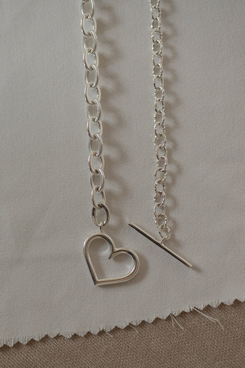 An elegant, ultra-modern chain necklace featuring a striking combination of two link styles and a decorative heart motif. A contemporary design with a romantic touch — perfect for everyday wear and special occasions. Handcrafted from 925 sterling silver. Explore the AMORE collection at UMIAR Jewellery and find your perfect piece!