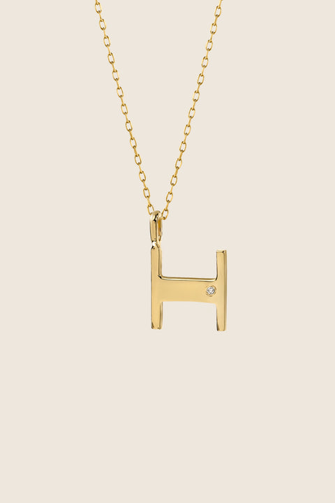 A delicate letter H pendant necklace inlaid with a natural diamond of 0.007 ct and 1.2 mm diameter. Suspended on a 50 cm chain, this timeless initial design offers a personal and elegant way to celebrate someone special. A refined keepsake that never goes out of style. Discover meaningful jewelry by UMIAR jewelry.