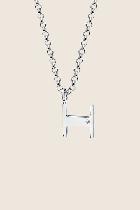 A delicate letter H pendant necklace inlaid with a natural diamond of 0.007 ct and 1.2 mm diameter. Suspended on a 50 cm chain, this timeless initial design offers a personal and elegant way to celebrate someone special. A refined keepsake that never goes out of style. Discover meaningful jewelry by UMIAR jewelry.