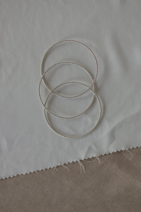 Discover elegance with UMIAR jewellery! This triple silver bangle, subtly textured with a twisted rope motif, is a timeless classic in a modern form. Perfect for both everyday and evening looks. From the AMORE collection — a symbol of hearts meeting. Add a distinctive accent to your jewellery wardrobe!