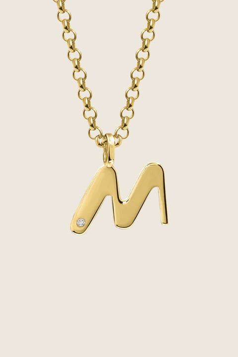 A delicate letter M pendant necklace inlaid with a natural diamond of 0.007 ct and 1.2 mm diameter. Suspended on a 50 cm chain, this timeless initial design offers a personal and elegant way to celebrate someone special. A refined keepsake that never goes out of style. Discover meaningful jewelry by UMIAR jewelry.