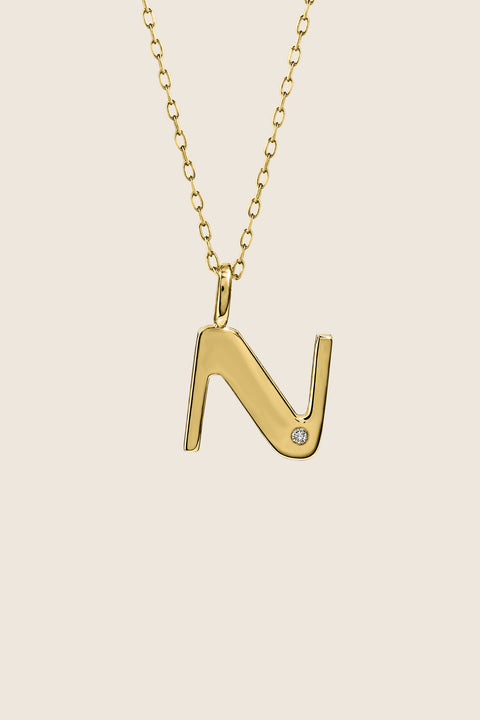 A delicate letter N pendant necklace inlaid with a natural diamond of 0.007 ct and 1.2 mm diameter. Suspended on a 50 cm chain, this timeless initial design offers a personal and elegant way to celebrate someone special. A refined keepsake that never goes out of style. Discover meaningful jewelry by UMIAR jewelry.
