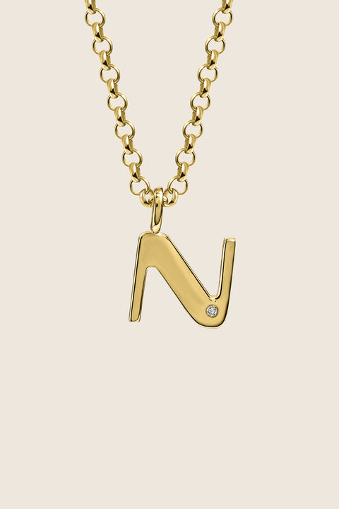 A delicate letter N pendant necklace inlaid with a natural diamond of 0.007 ct and 1.2 mm diameter. Suspended on a 50 cm chain, this timeless initial design offers a personal and elegant way to celebrate someone special. A refined keepsake that never goes out of style. Discover meaningful jewelry by UMIAR jewelry.