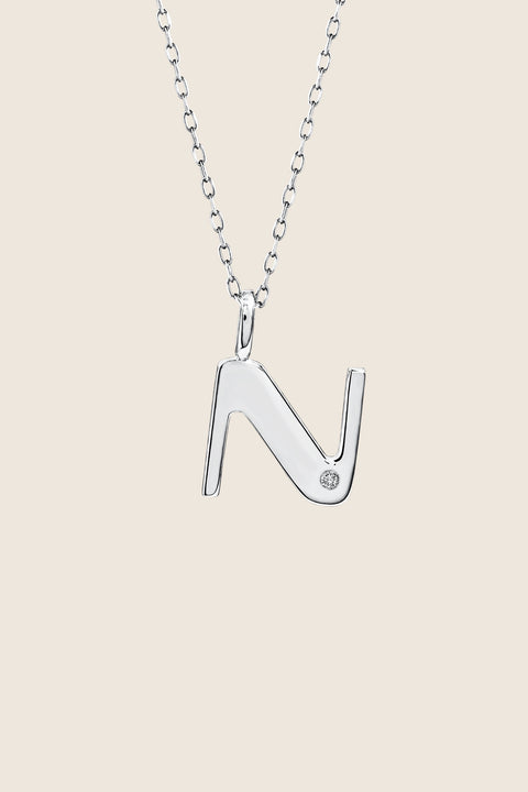 A delicate letter N pendant necklace inlaid with a natural diamond of 0.007 ct and 1.2 mm diameter. Suspended on a 50 cm chain, this timeless initial design offers a personal and elegant way to celebrate someone special. A refined keepsake that never goes out of style. Discover meaningful jewelry by UMIAR jewelry.