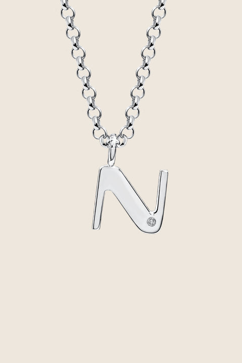 A delicate letter N pendant necklace inlaid with a natural diamond of 0.007 ct and 1.2 mm diameter. Suspended on a 50 cm chain, this timeless initial design offers a personal and elegant way to celebrate someone special. A refined keepsake that never goes out of style. Discover meaningful jewelry by UMIAR jewelry.