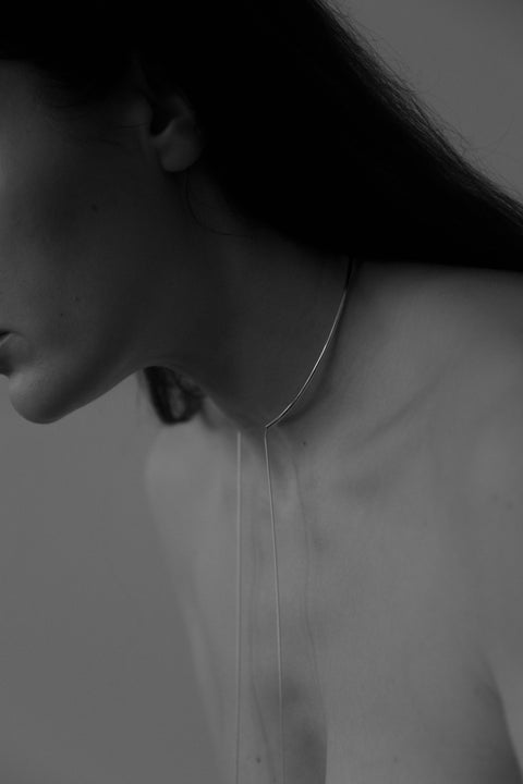 A handcrafted choker necklace combining the ORA hoop, a chain, and tubular end details. Designed for versatile styling, the chain can be tied, layered, or worn loose, including as a back neckline accent. A modern piece that adapts effortlessly to your style. Discover expressive minimalism by UMIAR jewelry.