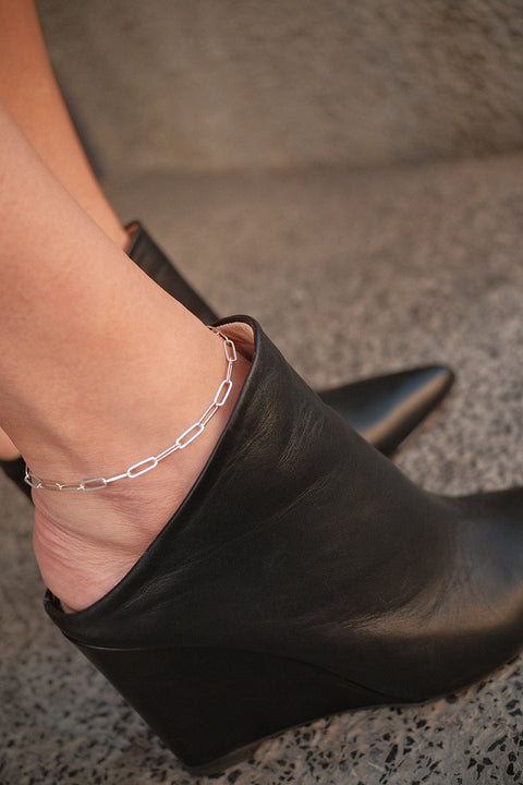 A stylish chain anklet made from flat, rectangular links with an adjustable length of approximately 26 cm. A timeless jewelry classic that enhances summer styling and beautifully highlights the ankle. Perfect with sandals and heels, and equally elegant with loafers during transitional seasons. Discover versatile, modern elegance by UMIAR jewelry.