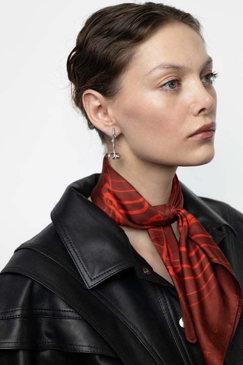 Discover a silk scarf with an original rose design by UMIAR jewellery, where expressive lines form a unique floral composition. Contrasting shades of red, burgundy, and carmine combine elegance with contemporary trends. This exceptional scarf, made from 100% natural silk, is part of the PROFONDO ROSSO collection. A perfect gift — beautifully packaged and ready to delight. Explore unique jewellery and silk scarves by UMIAR.