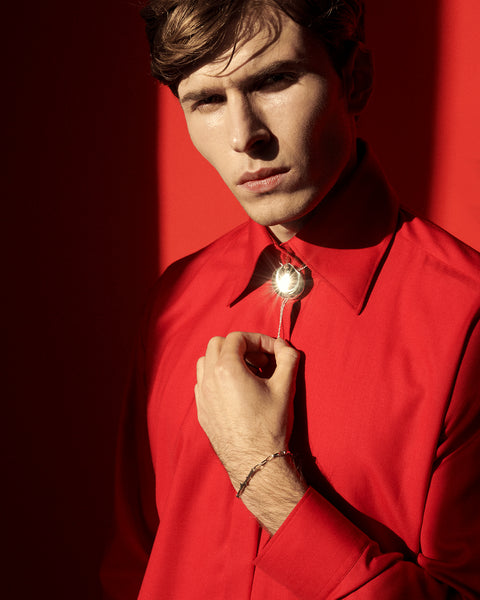 Discover the bolo tie reimagined in a jewellery form by UMIAR, inspired by the geometry of a rose petal. A striking accessory that doubles as an original necklace, perfect for elevating any outfit. Handcrafted from 925 sterling silver and 24-carat gold-plated silver. The adjustable decorative element allows you to tailor the length to your style. A distinctive piece from the PROFONDO ROSSO collection. Explore the unique jewellery forms created by UMIAR.