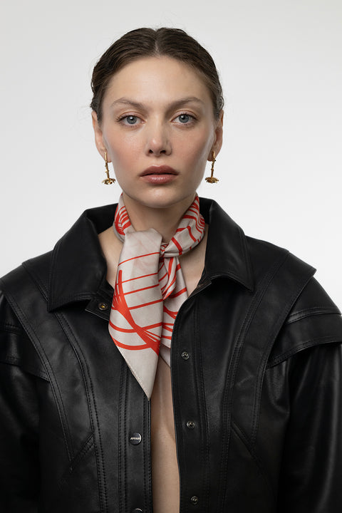 Discover a silk scarf with an original rose design by UMIAR jewellery, where expressive lines form a distinctive floral composition. Contrasting shades of ecru and carmine blend elegance with modern style. This exceptional scarf, made from 100% natural silk, is part of the PROFONDO ROSSO collection. A perfect gift — beautifully packaged and ready to delight. Explore unique jewellery and silk scarves by UMIAR.