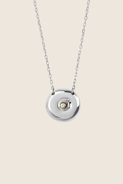 Discover the elegant pendant necklace with a natural diamond by UMIAR jewellery, handcrafted from 925 sterling silver. Its unique round disc with a recessed bead blends timeless style with a modern touch, symbolising femininity, closeness, and the cycles of life. A perfect gift for special occasions — shop now!