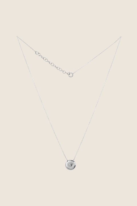 Discover the elegant pendant necklace with a natural diamond by UMIAR jewellery, handcrafted from 925 sterling silver. Its unique round disc with a recessed bead blends timeless style with a modern touch, symbolising femininity, closeness, and the cycles of life. A perfect gift for special occasions — shop now!