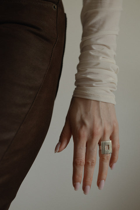 Discover a bold ring with a square element and a fluted pattern. A modern design with a subtle “window” and timeless elegance. Perfect for power-dressing looks and minimalist outfits. Explore the UMIAR collection!