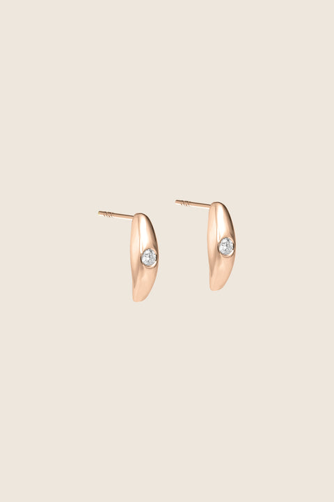 Elegant stud earrings featuring a natural diamond, handcrafted in 14k rose gold. Their softly rounded setting and the diamond’s intense brilliance create a refined, timeless accent — an ideal gift and a sophisticated detail for both everyday and evening looks. Discover the quality of UMIAR jewelry and order online.
