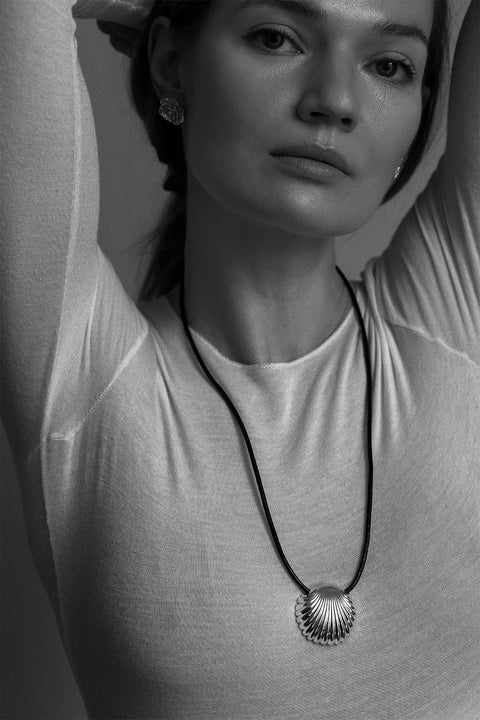 This large pendant featuring a shell inspired by “The Birth of Venus” captivates with its sculptural form and the raw texture of the black cord. An artistic, eye-catching accent that complements both minimalist and elegant looks. Available in sterling silver and gold-plated sterling silver. Discover the distinctive design of UMIAR jewelry and order online.