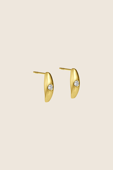 Elegant stud earrings featuring a natural diamond set in a softly rounded, delicate setting. The subtle brilliant-cut stone catches the eye with its intense sparkle, adding refined elegance to both everyday and evening looks. Discover the quality of UMIAR jewelry and order online.