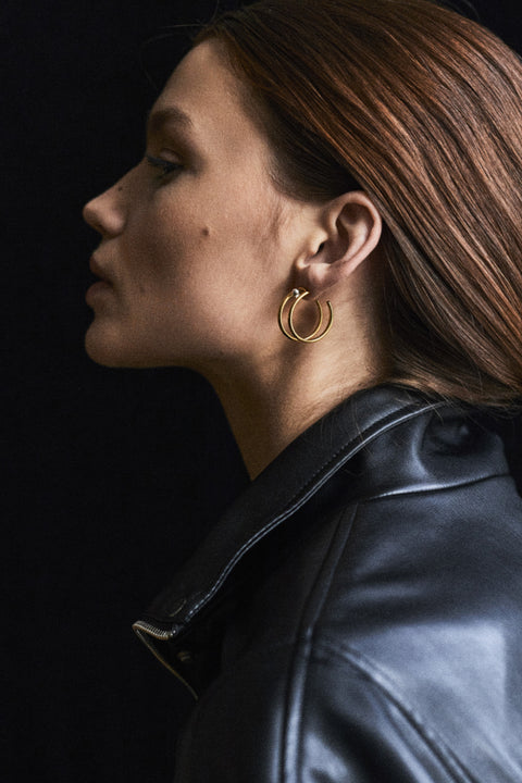 Discover the versatility of these specially designed earring attachments, echoing the form of doubled rings. They allow you to adapt your earrings to the moment and your mood, wearing them in any configuration — with ARNO hoops, DOTA studs, or paired with other earrings from your collection. Handcrafted from  925 sterling silver, 24k gold-plated 925 silver, and 14k gold.