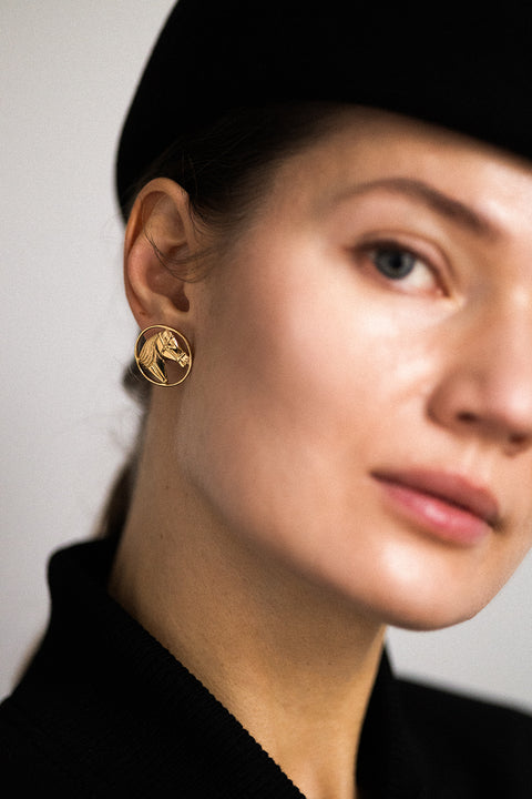 The large HAST horse-motif earrings captivate with their sculpted horse heads — a symbol of freedom, strength and elegance. Their interplay of openwork lightness and bold form makes them a perfect accessory for evening looks. Crafted in sterling silver or gold-plated sterling silver. Discover the unique style of UMIAR jewelry and order online.