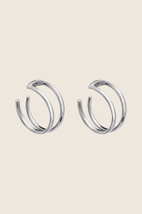 Discover the versatility of these specially designed earring attachments, echoing the form of doubled rings. They allow you to adapt your earrings to the moment and your mood, wearing them in any configuration — with ARNO hoops, DOTA studs, or paired with other earrings from your collection. Handcrafted from  925 sterling silver, 24k gold-plated 925 silver, and 14k gold.