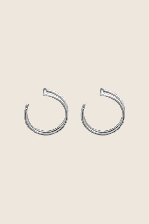 Discover the versatility of these specially designed earring attachments, echoing the form of doubled rings. They allow you to adapt your earrings to the moment and your mood, wearing them in any configuration — with ARNO hoops, DOTA studs, or paired with other earrings from your collection. Handcrafted from  925 sterling silver, 24k gold-plated 925 silver, and 14k gold.