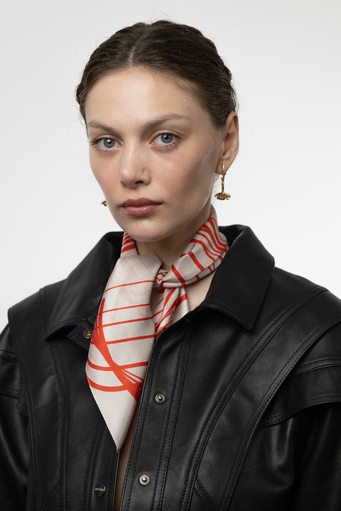 Discover a silk scarf with an original rose design by UMIAR jewellery, where expressive lines form a distinctive floral composition. Contrasting shades of ecru and carmine blend elegance with modern style. This exceptional scarf, made from 100% natural silk, is part of the PROFONDO ROSSO collection. A perfect gift — beautifully packaged and ready to delight. Explore unique jewellery and silk scarves by UMIAR.