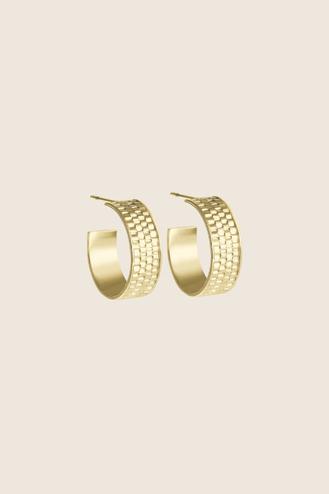 These gold hoop earrings with a textured braided finish combine modern character with timeless elegance. Handcrafted in 14k yellow gold, they beautifully reflect the light, adding a subtly dynamic accent to both everyday and evening looks. Discover the exceptional quality of UMIAR jewelry and order online.