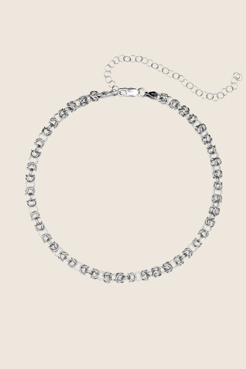 This elegant short necklace crafted from a meticulously woven chain blends classic form with a bold, distinctive character. The decorative structure of interlaced links subtly catches the light, accentuating the neckline and adding depth to any look. Available in sterling silver and gold-plated sterling silver. Discover the unique style of UMIAR jewelry and order online.