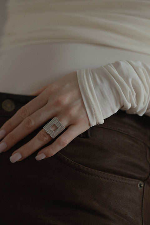 Discover a bold ring with a square element and a fluted pattern. A modern design with a subtle “window” and timeless elegance. Perfect for power-dressing looks and minimalist outfits. Explore the UMIAR collection!