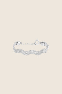 Discover the delicate wave bracelet from UMIAR jewelry, crafted from silver filigree. This decorative band, inspired by the ribbed stripes of silk, exudes casual elegance. The wavy form perfectly highlights the beauty of the wrist. Made in a limited edition, it is perfect for lovers of unique jewelry. Add this exceptional bracelet to your collection today!