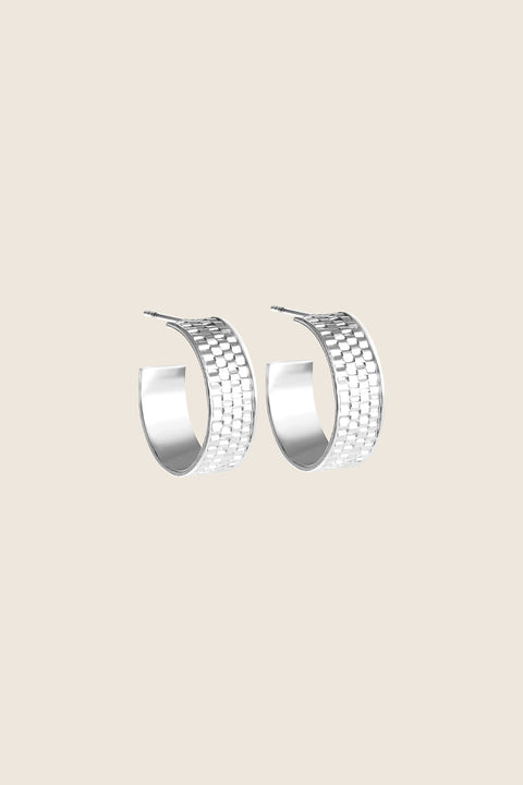 These striking hoop earrings with a textured braided finish combine modern style with timeless elegance. Crafted in 925 sterling silver or gold-plated sterling silver, they beautifully catch the light, adding a dynamic accent to both everyday and evening looks. Discover the quality of UMIAR jewelry and enrich your collection with a bold, distinctive detail.