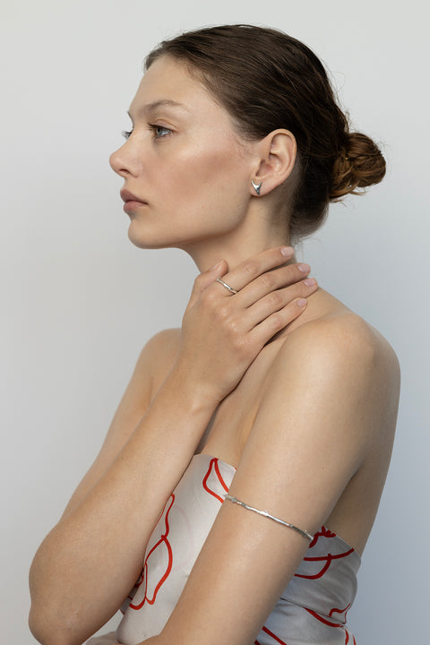 Discover this upper arm bracelet inspired by a rose branch, blending simple forms with refined detail — a decorative texture echoing the stem itself. A tribute to the ’90s, Pamela Anderson, and her iconic tattoo. Handcrafted from precious materials: 925 sterling silver and 24-carat gold-plated silver. A piece from the PROFONDO ROSSO collection, inspired by the beauty of the rose and created to offer unique jewellery forms and stylish scarves.