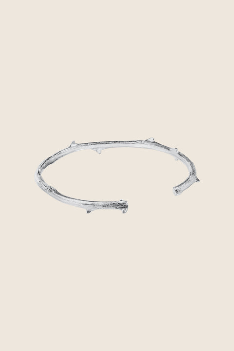 Discover this unique rigid bracelet inspired by a rose branch, combining simple forms with refined detailing. The decorative stem-like texture adds a natural, organic character. Handcrafted from 925 sterling silver and 24-carat gold-plated silver. A piece from the PROFONDO ROSSO collection, created with the beauty of the rose in mind and designed to offer truly distinctive jewellery forms.