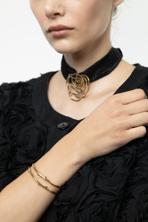 Discover this unique rigid bracelet inspired by a rose branch, combining simple forms with refined detailing. The decorative stem-like texture adds a natural, organic character. Handcrafted from 925 sterling silver and 24-carat gold-plated silver. A piece from the PROFONDO ROSSO collection, created with the beauty of the rose in mind and designed to offer truly distinctive jewellery forms.