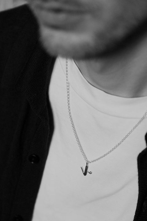 A delicate letter K pendant necklace inlaid with a natural diamond of 0.007 ct and 1.2 mm diameter. Suspended on a 50 cm chain, this timeless initial design offers a personal and elegant way to celebrate someone special. A refined keepsake that never goes out of style. Discover meaningful jewelry by UMIAR jewelry.