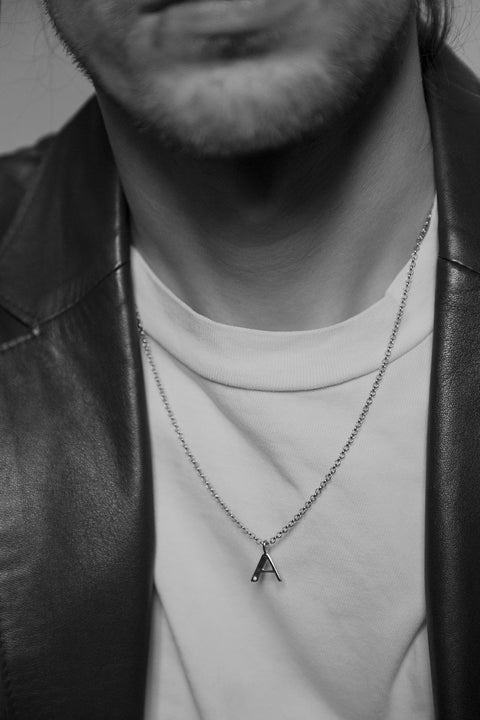 A delicate letter A pendant necklace inlaid with a natural diamond of 0.007 ct and 1.2 mm diameter. Suspended on a 50 cm chain, this timeless initial design offers a personal and elegant way to celebrate someone special. A refined keepsake that never goes out of style. Discover meaningful jewelry by UMIAR jewelry.