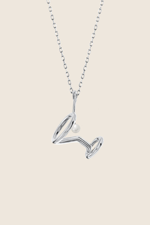 A unique necklace inspired by the shape of a martini glass, created to mark the opening of the Jewellery Bar boutique. Featuring a natural pearl symbolizing the cocktail’s olive and a 50 cm chain, this design blends playful elegance with refined craftsmanship. Discover distinctive storytelling jewelry by UMIAR jewelry.